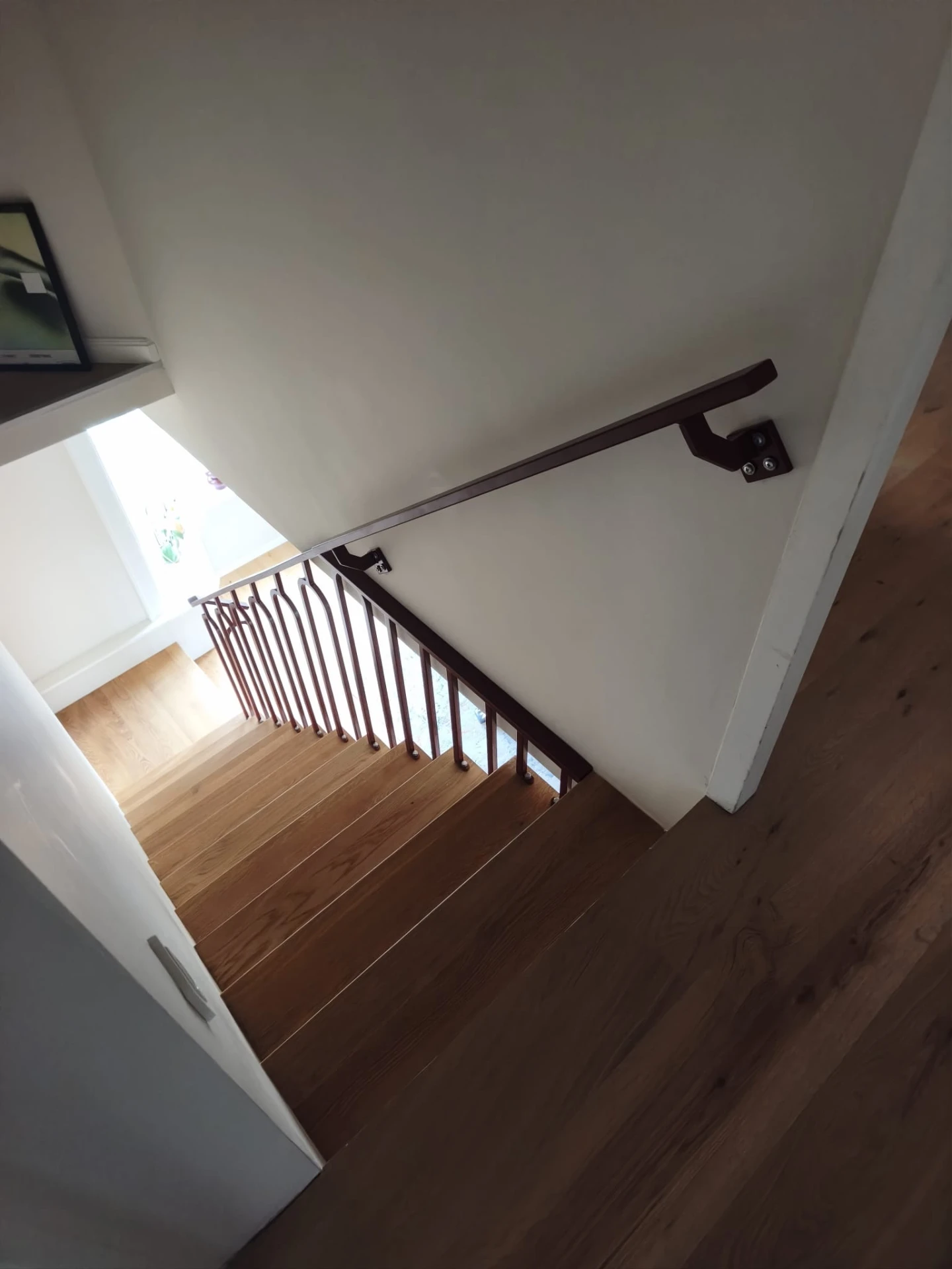 Detail van de stalen balustrade en wandhandgreep met matte poedercoating RAL 3005, gezien vanaf de bovenverdieping